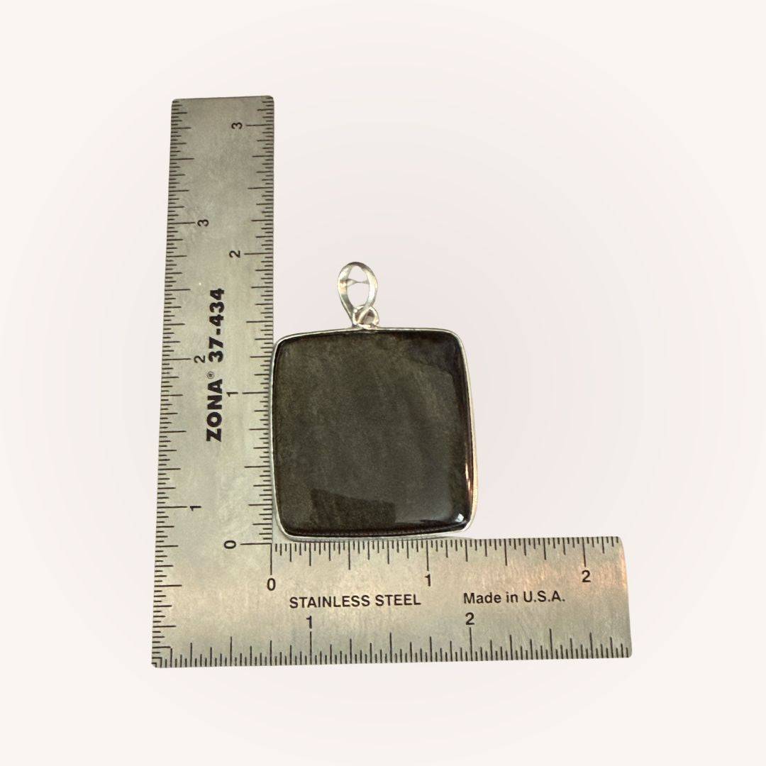 Square Gold Sheen Obsidian Pendant beside ruler for scale. Jewelry piece designed for empowerment and shadow work practices.