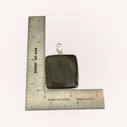 Square Gold Sheen Obsidian Pendant beside ruler for scale. Jewelry piece designed for empowerment and shadow work practices.