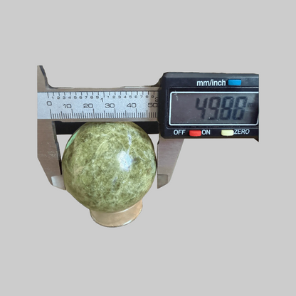 Green Infinite Healing Stone Sphere - Heart Chakra Aid | Serpentine Chrysotile measured at 49.88mm diameter with digital caliper, ideal for energy healing rituals.