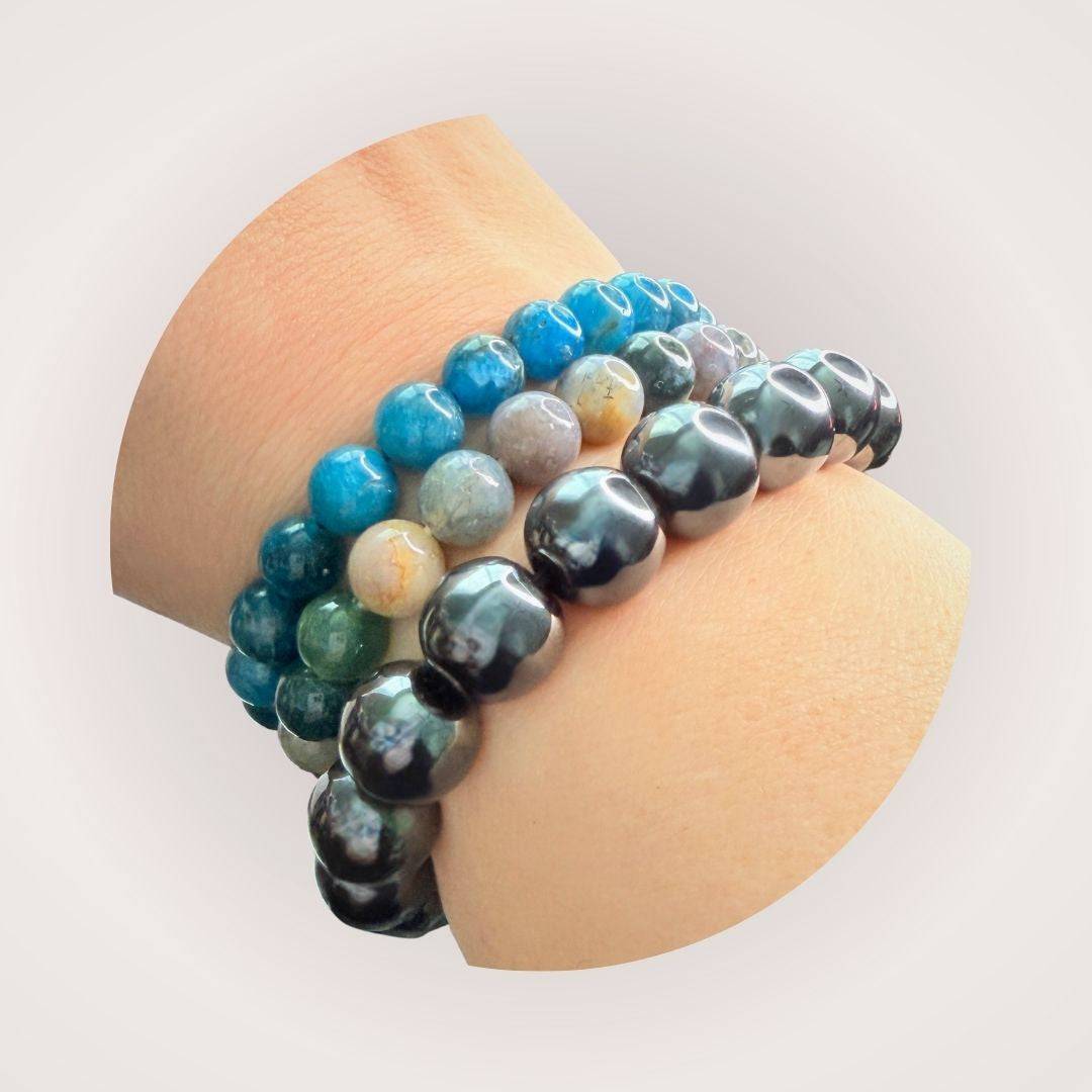 Stacked wristwear featuring Hematite 12mm Beaded Bracelet - Grounding & Stable Protective with other colorful gemstone bracelets for layered style.