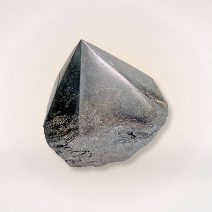 Polished hematite point tower featuring a sleek, reflective surface and raw stone base, perfect for mental clarity and mineral enthusiasts.