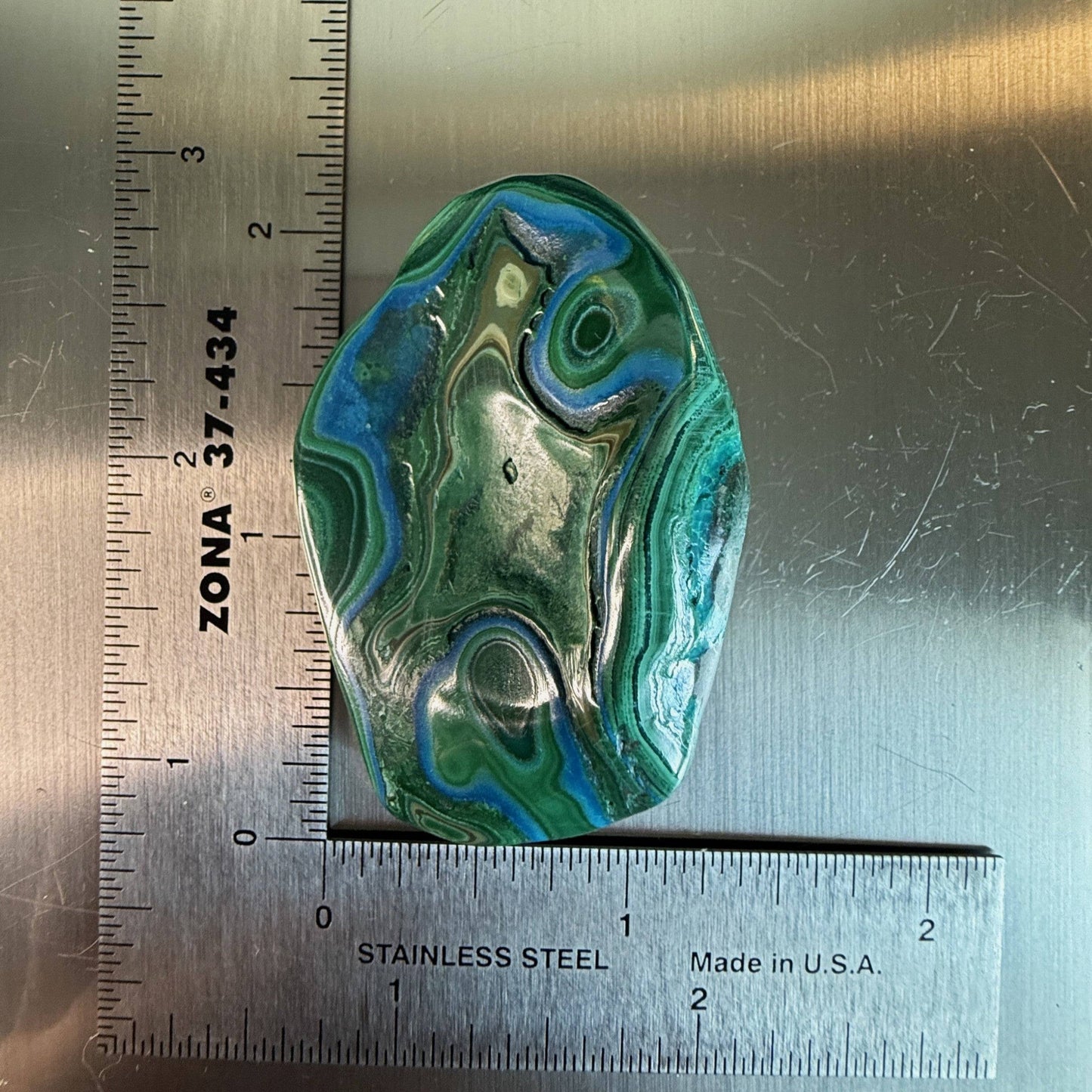 Oval-shaped MalaColla Freeform with striking blue and green banding of chrysocolla and malachite, displayed on a ruler for dimensions.