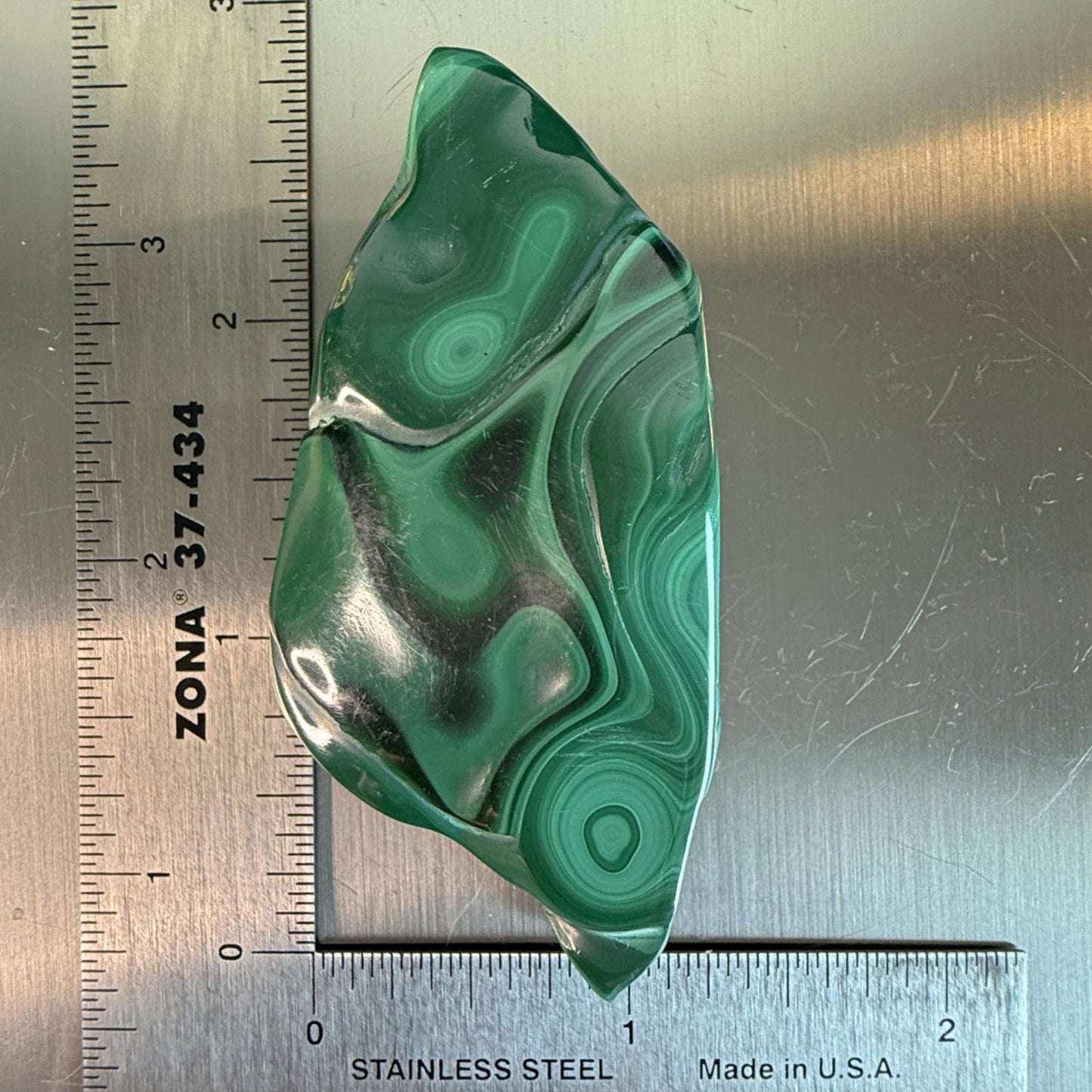 Green banded MalaColla Freeform with polished malachite surface, elongated shape measured against a ruler.