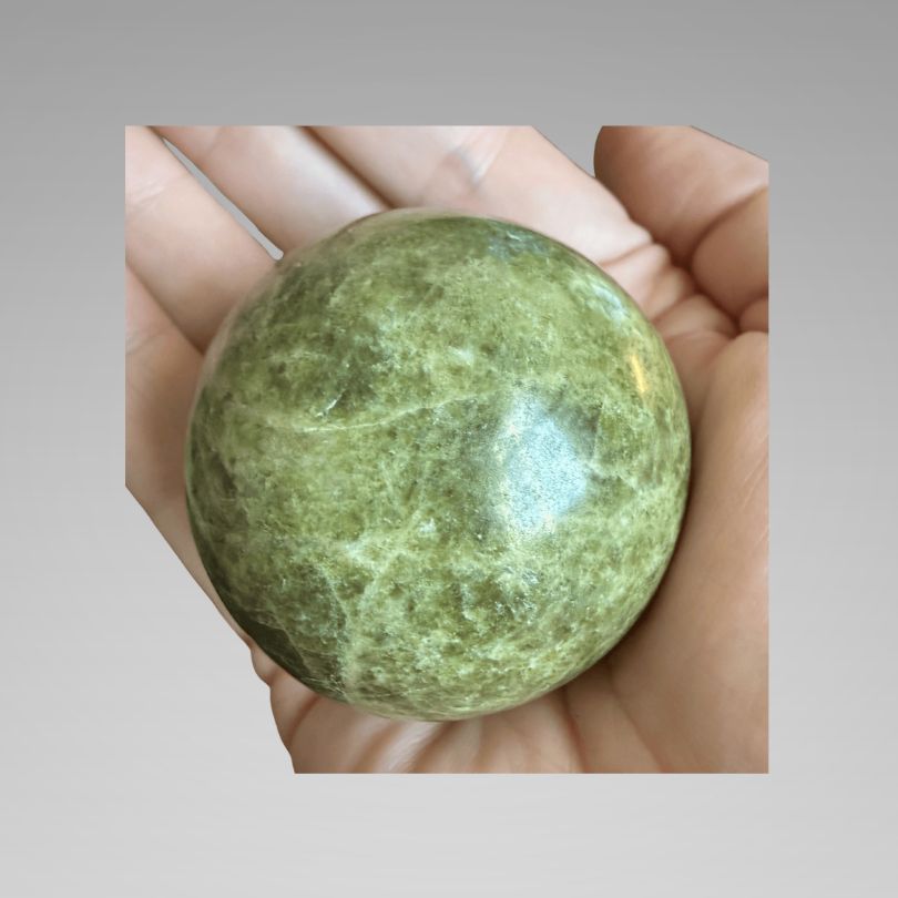 Green Infinite Stone Sphere - Heart Chakra Aid made from Serpentine & Chrysotile, shown in hand for size reference. Ideal for energy healing and balance.