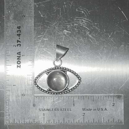 Labradorite Evil Eye Pendant with central gemstone set in silver, symbolizing transformation and protection, shown with ruler for size reference.