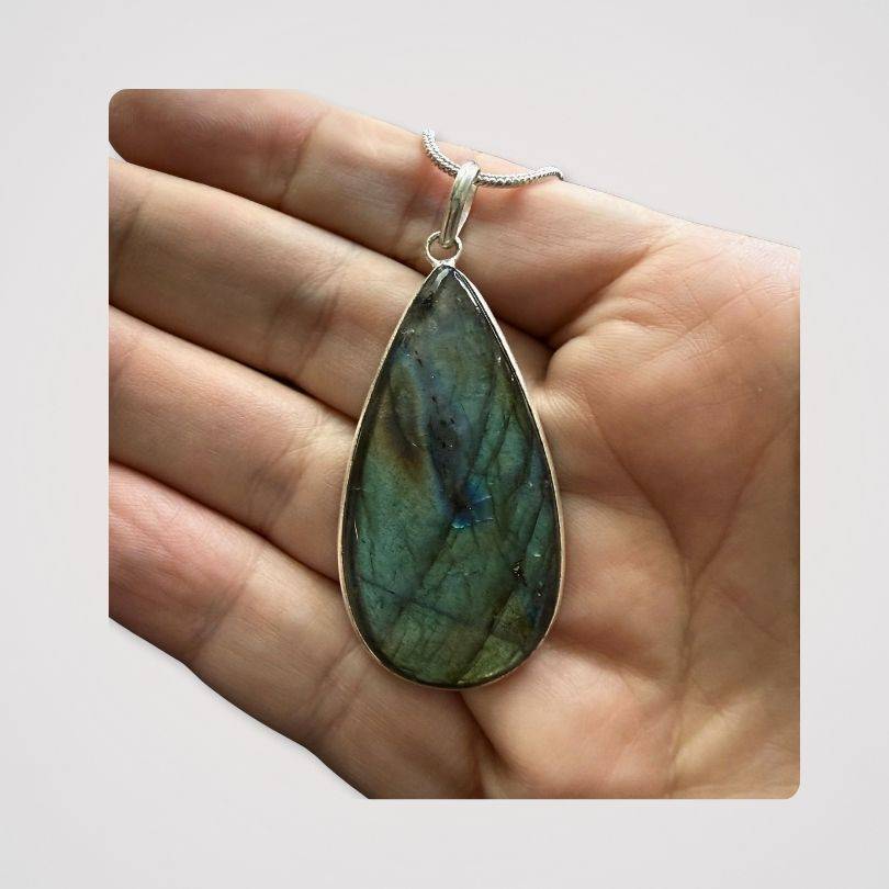 Labradorite Statement Pendant shown in hand, highlighting its size and natural iridescence for spiritual jewelry lovers.