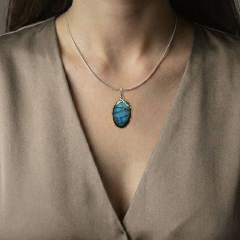 Labradorite Classic Pendant worn on model, showcasing its elegant blue flash and spiritual benefits of intuition and protection.