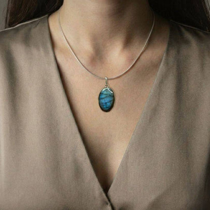 Labradorite Classic Pendant worn on model, showcasing its elegant blue flash and spiritual benefits of intuition and protection.