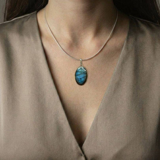 Labradorite Classic Pendant worn on model, showcasing its elegant blue flash and spiritual benefits of intuition and protection.