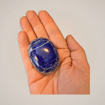 Polished Lapis Lazuli stone in hand for spiritual healing