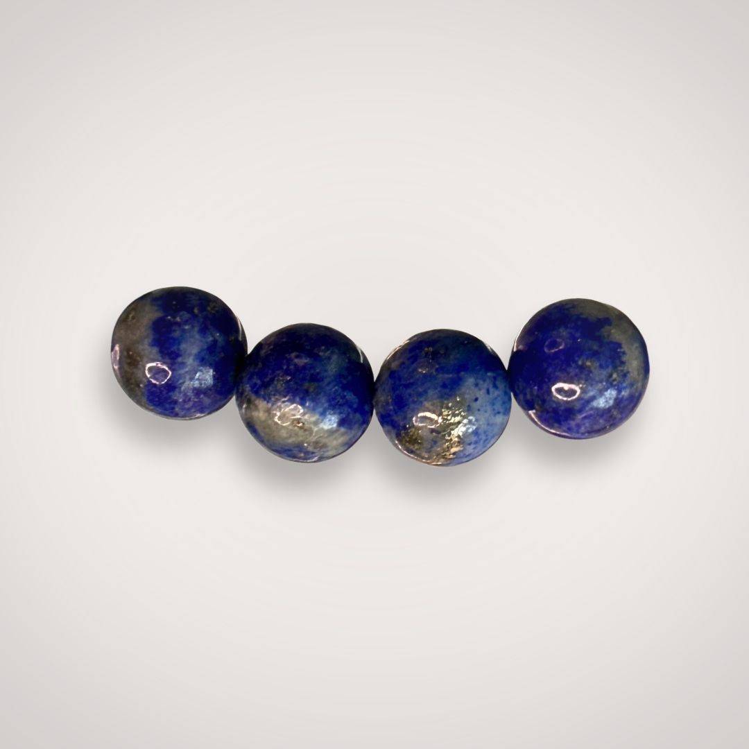 Close-up of four 8mm Lapis Lazuli beads from the bracelet, showing natural blue hues with gold and white marbling for clarity and wisdom.