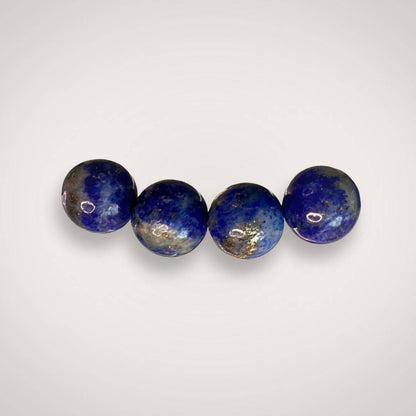 Close-up of four 8mm Lapis Lazuli beads from the bracelet, showing natural blue hues with gold and white marbling for clarity and wisdom.