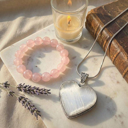 Bond of the Heart aligned pairing with Selenite heart pendant and Rose Quartz bracelet, styled with candle and lavender for love energy.