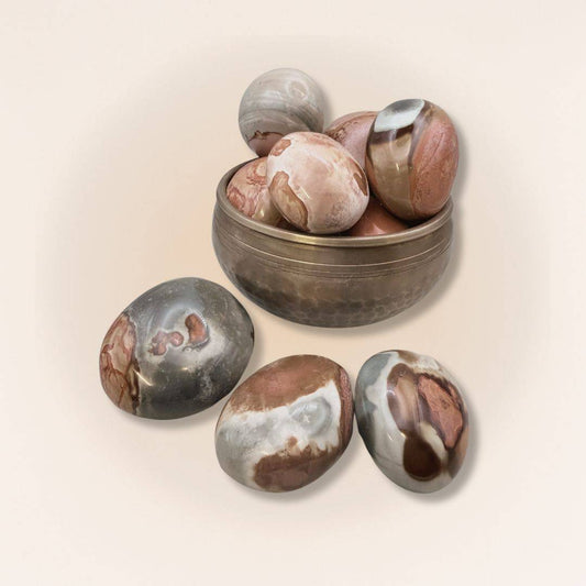 Collection of medium Polychrome Jasper palm stones in a brass bowl, showcasing unique patterns for grounding and stability rituals.