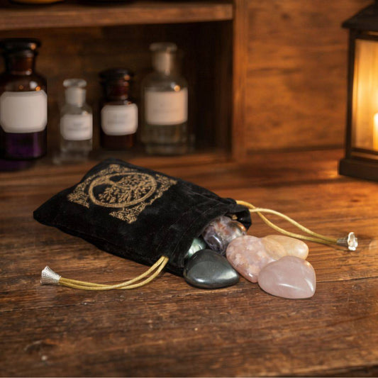 Polished Madagascar heart stones displayed with a black velvet pouch in a warm Mystic Parcel apothecary setting.
