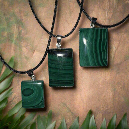 Three natural malachite pendants in small, medium, and large sizes, each set in silver bales on 20-inch waxed cotton cords, arranged side by side.