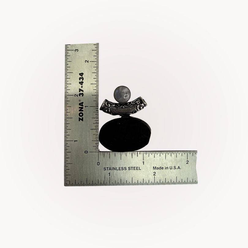 Moonstone & Black Tourmaline Pendant next to ruler for scale, highlighting size and handcrafted silver bezel design for grounding energy.