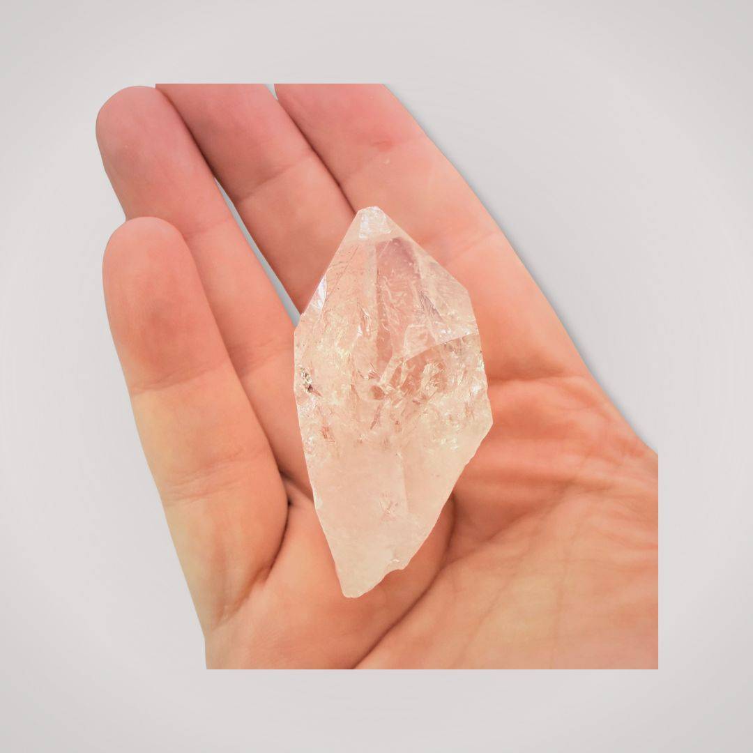 Hand holding a Clear Quartz Terminated Point specimen, highlighting its natural transparency and pointed structure for metaphysical use.