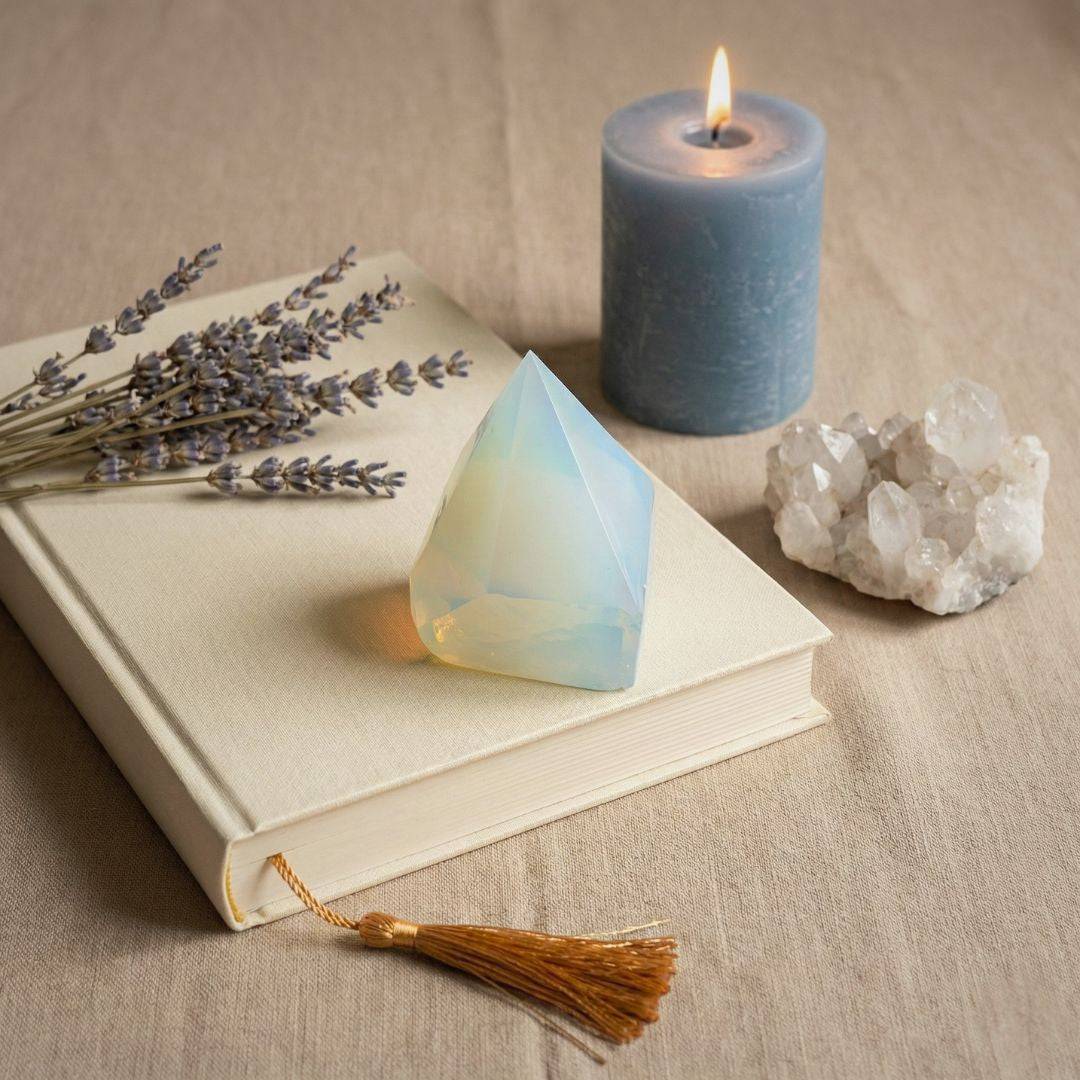 Opalite top polish point tower placed on a book with lavender, candle, and quartz, enhancing calm and balance in home decor settings.
