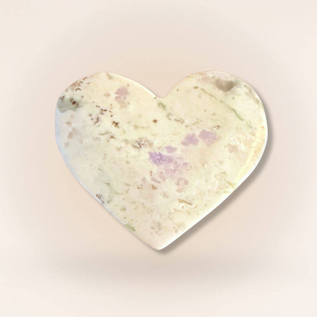 Light-toned Peace Jade heart palm stone with subtle lavender and green hues, made from serpentine and stichtite for inner peace.