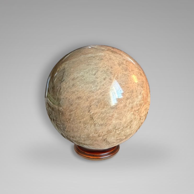 Hand-polished Flashy Peach Moonstone Sphere — Nurturing & Balancing with soft glow and earthy tones, ideal for gemstone enthusiasts.