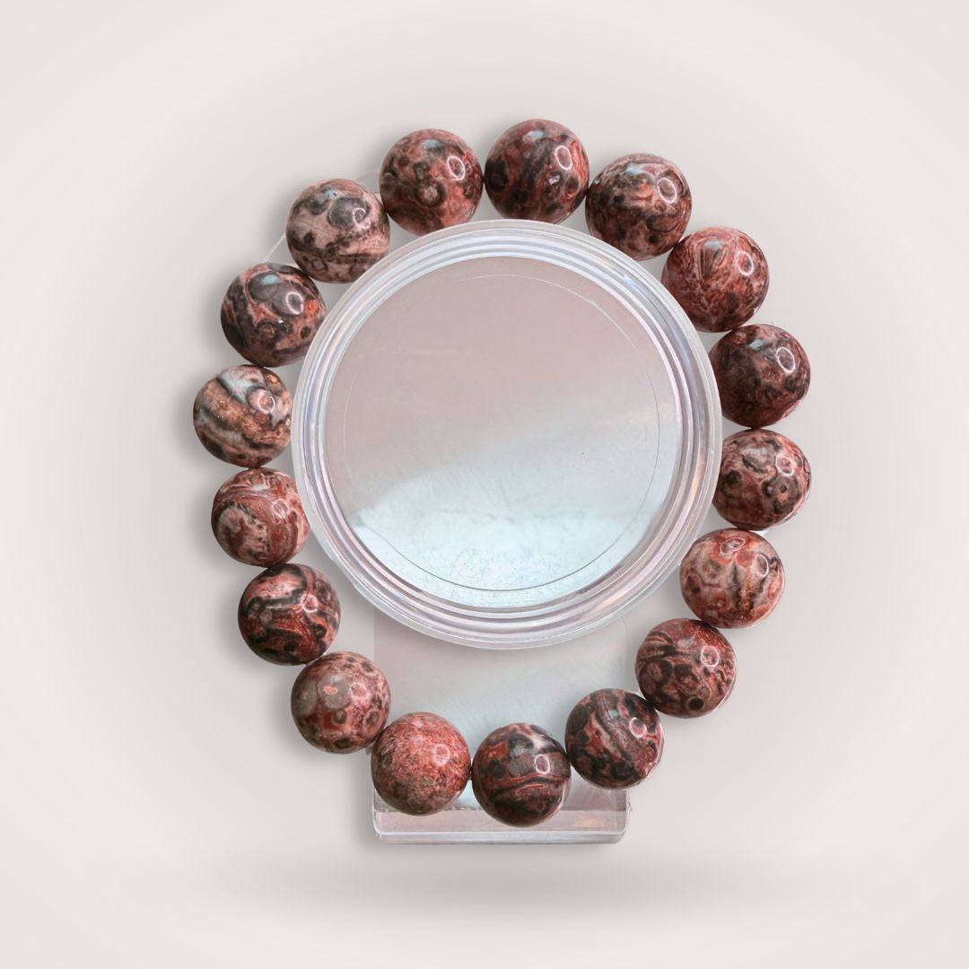 Picasso Jasper 12mm Beaded Bracelet for Creativity & Grounding, featuring polished round beads with earthy red and brown tones on a display stand.