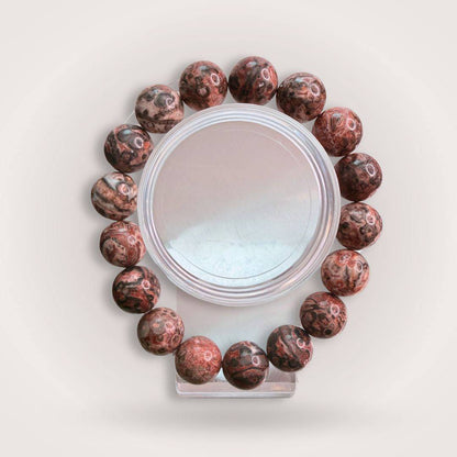 Picasso Jasper 12mm Beaded Bracelet for Creativity & Grounding, featuring polished round beads with earthy red and brown tones on a display stand.