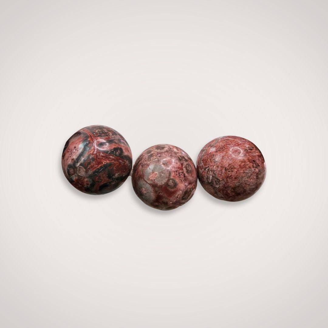 Close-up of three Picasso Jasper 12mm beads showcasing unique painterly patterns in red, brown, and gray tones, ideal for creative energy and balance.