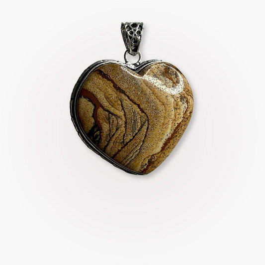 Close-up of Picture Jasper heart pendant from the Still Point Aligned Pairing, showcasing earthy tones and natural stone patterns in a silver setting.