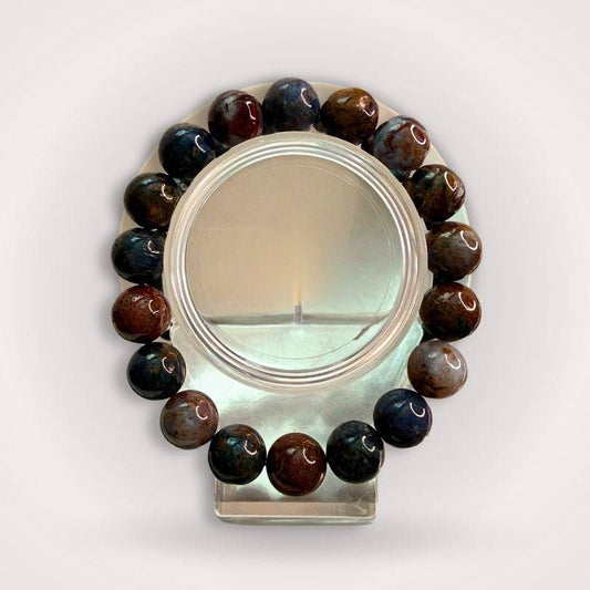 Pietersite 12mm beaded bracelet displayed on a clear stand, showcasing its bold natural banding and deep earthy tones for clarity and courage.