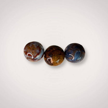 Close-up of three 12mm Pietersite beads with swirling patterns in blue, brown, and gold, emphasizing natural beauty and spiritual clarity.