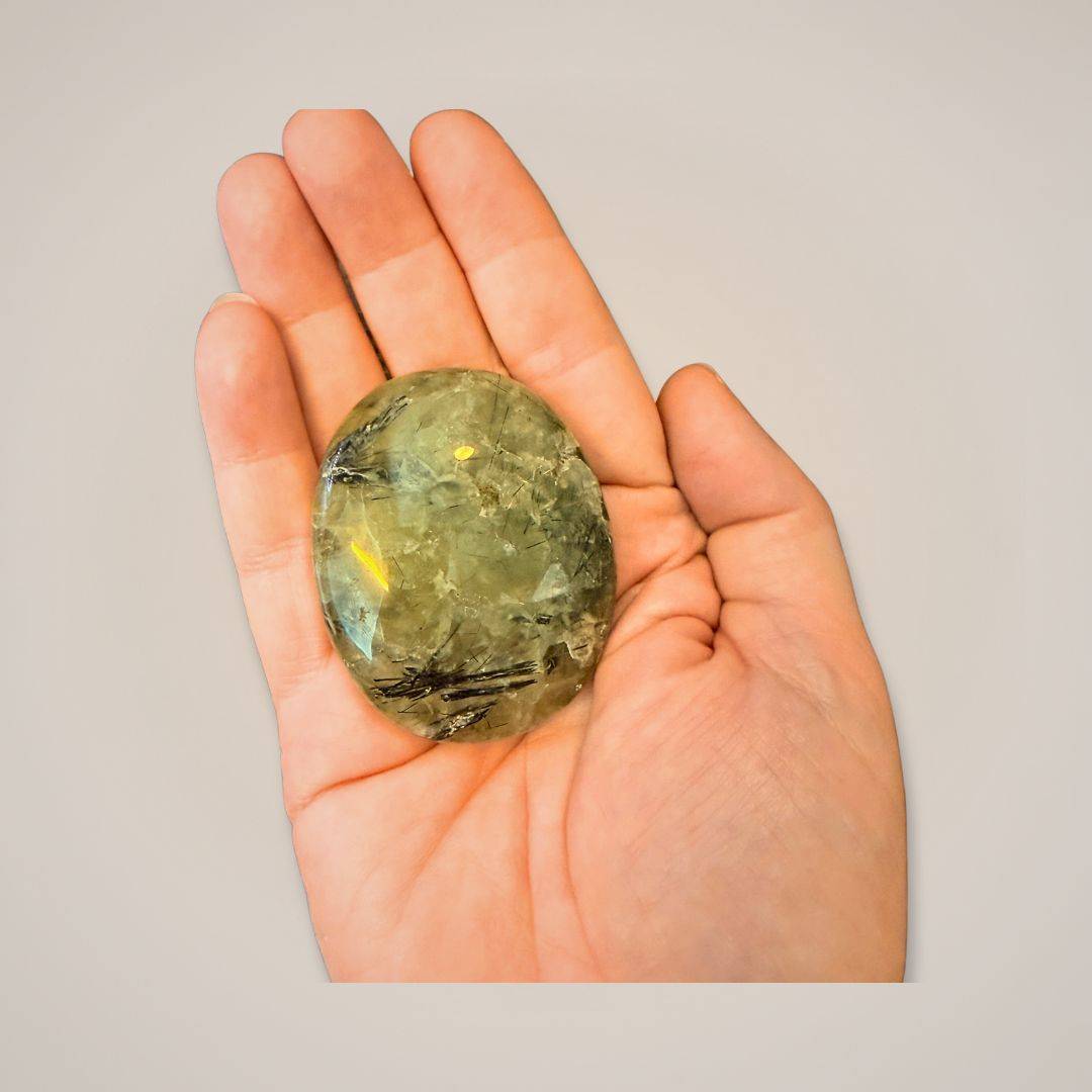 Hand holding polished Prehnite gemstone