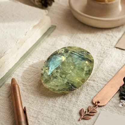 Prehnite palm stone on textured fabric
