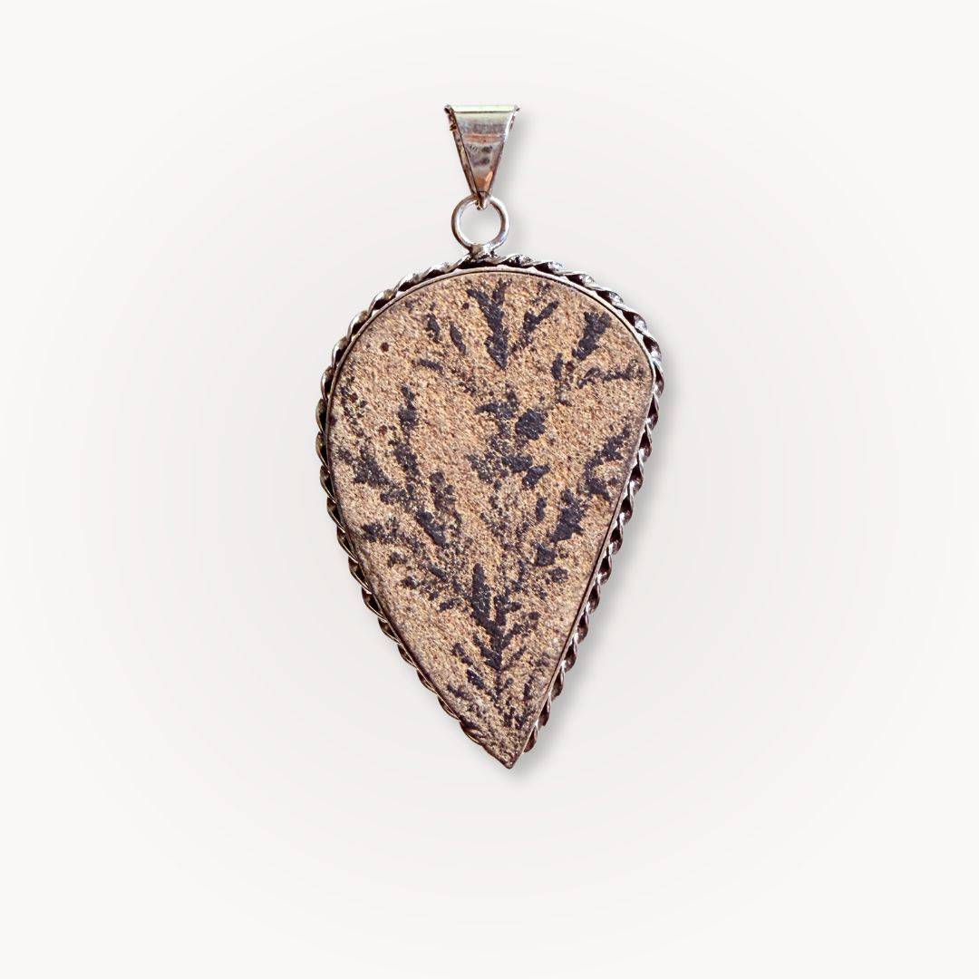 Close-up of Psilomelane Jasper Pendant featuring dark lightning branch inclusions. Teardrop shape set in twisted silver frame.