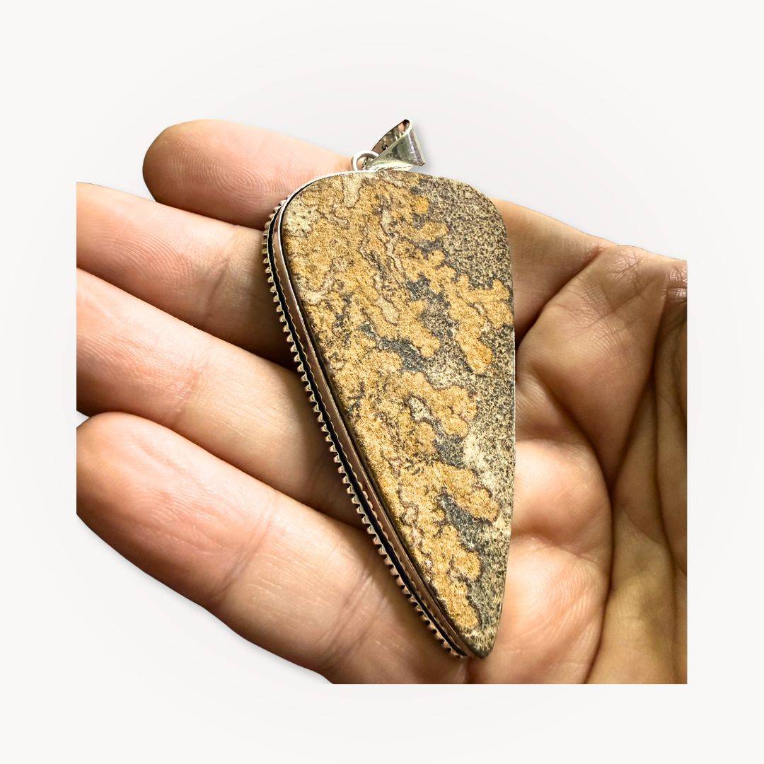 Psilomelane Jasper Pendant | Grounding, Protection, Self-awareness. Pendant held in hand to display its size, texture, and handcrafted silver bezel setting.
