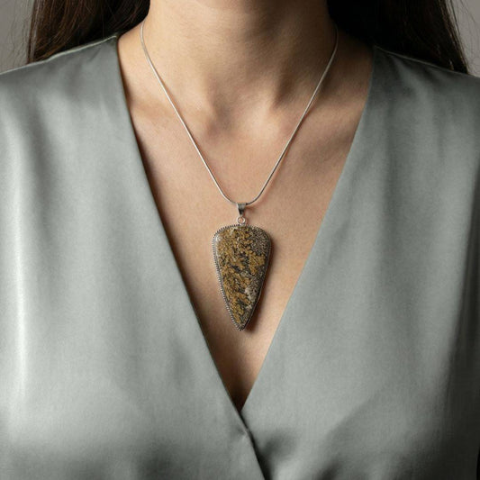 Psilomelane Jasper Pendant | Grounding, Protection, Self-awareness. Pendant worn on model, showcasing its bold size and natural stone texture.