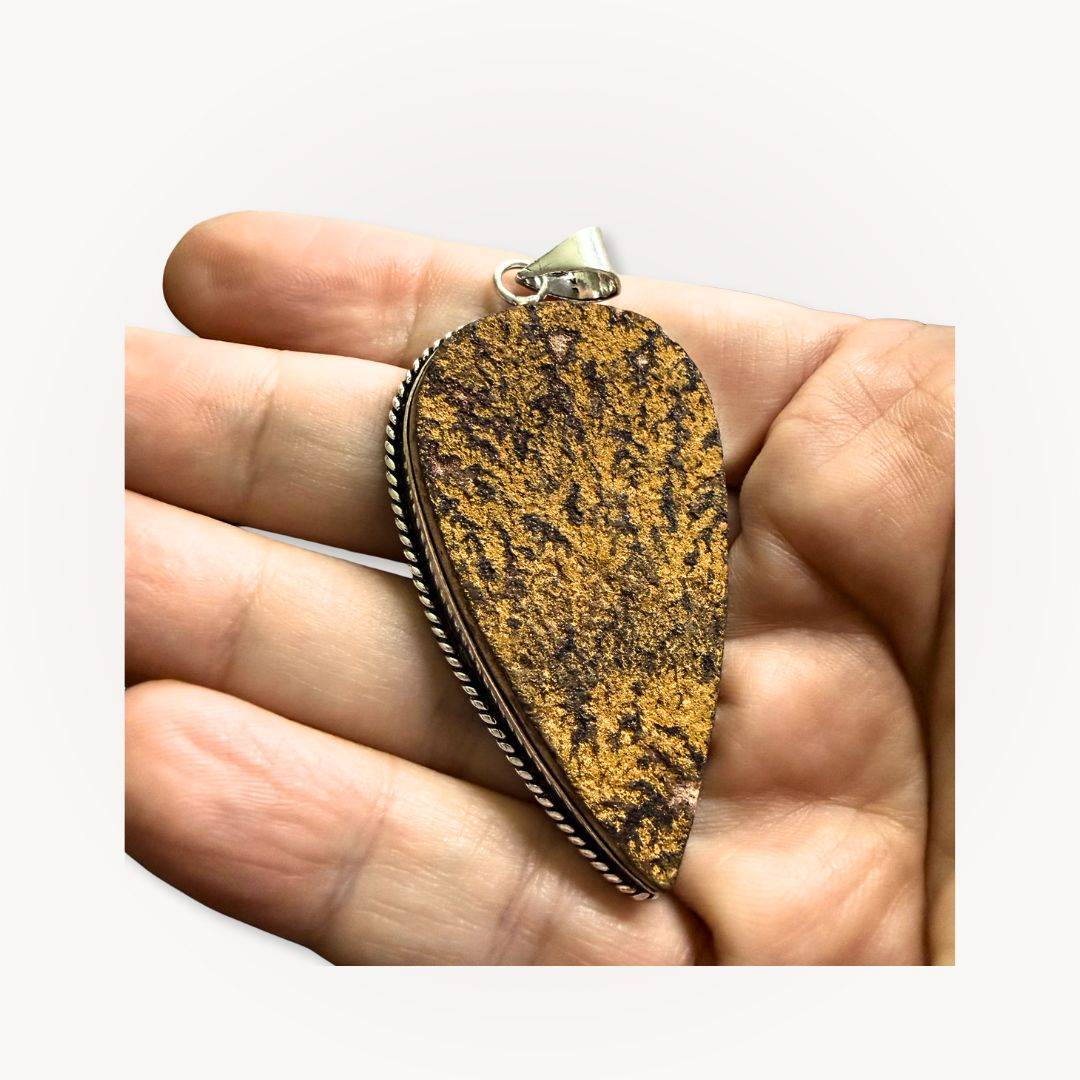 Handheld Psilomelane Jasper Pendant highlighting its grounding energy and intricate veining, perfect for reflection and protection.
