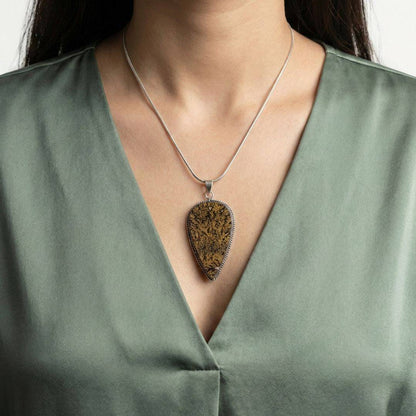 Psilomelane Jasper Pendant worn on a model, showcasing its bold teardrop design and earthy tones for grounding and integration.