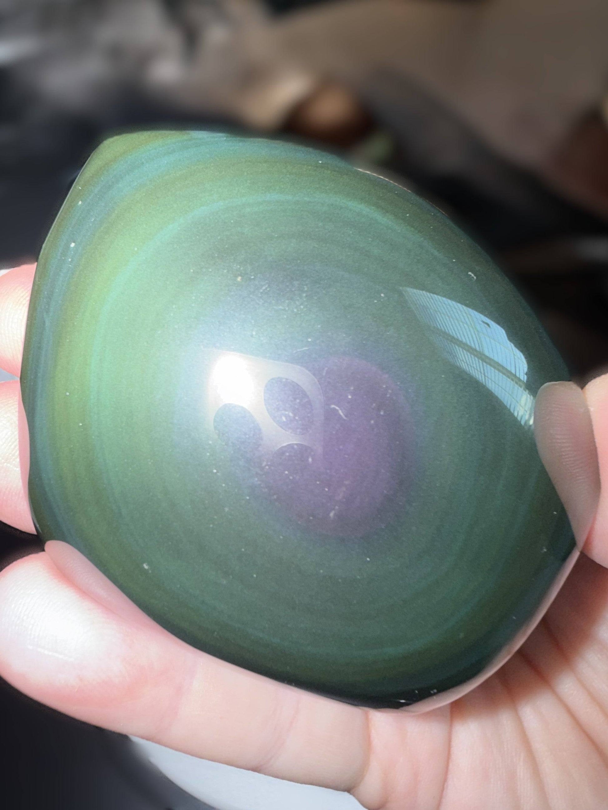 Rainbow Obsidian Freeform with luminous green and teal rings radiating from the center.