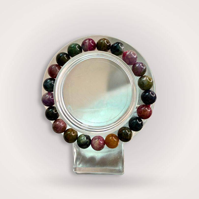 Rainbow Tourmaline Beaded Bracelet 9mm displayed on a clear stand, showcasing multicolored polished beads for emotional balance and heart alignment.