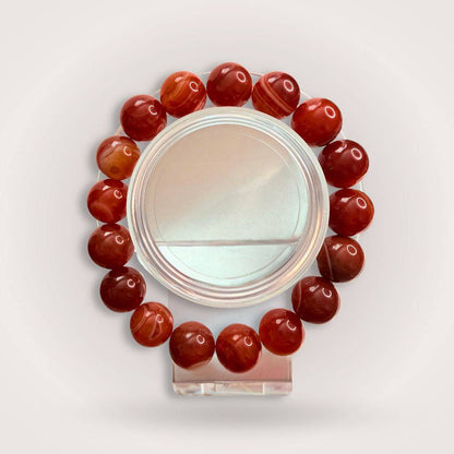 Red Botswana Agate 12mm Beaded Bracelet featuring polished round stones for grounding and emotional stability. Handcrafted jewelry for calm energy.
