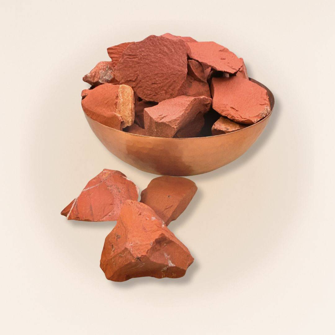 Multiple Red Jasper raw stones in a copper bowl, showcasing earthy tones and rough texture for grounding energy and crystal healing rituals.