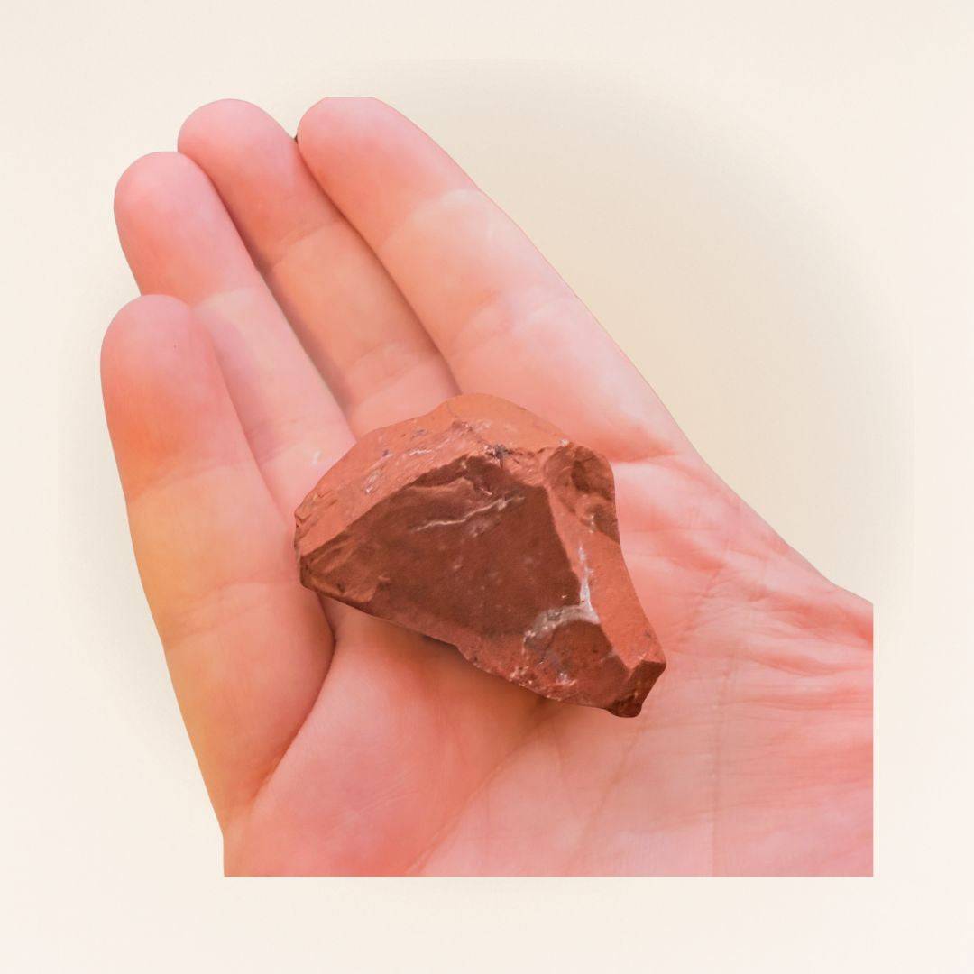 Hand holding a Red Jasper raw piece from Brazil, highlighting its size and natural form for use in meditation or gemstone collecting.