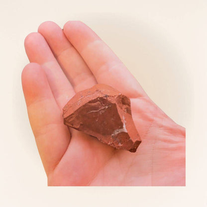 Hand holding a Red Jasper raw piece from Brazil, highlighting its size and natural form for use in meditation or gemstone collecting.