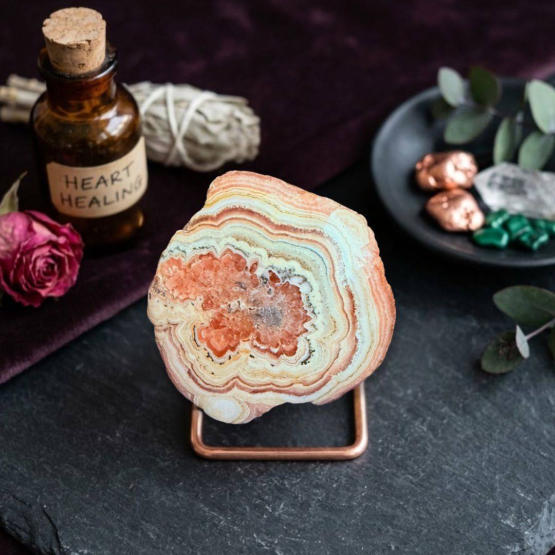 Rhodochrosite mineral specimen on display with healing crystal accessories