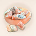 Rhodochrosite tumbled stones in a wooden bowl, pink and white mineral rocks for collectibles and healing