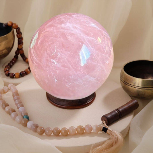 Madagascar Rose Quartz Sphere 350–400g placed on an altar with prayer beads and singing bowls, ideal for self-love and meditation rituals.