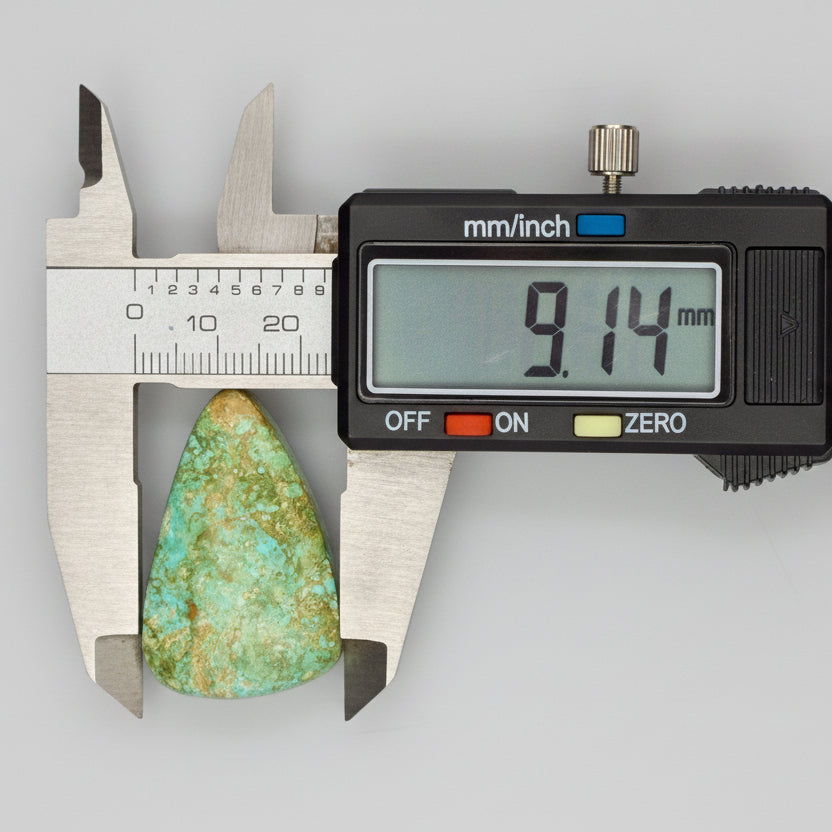Royston Turquoise Cabochon 58.8ct measured at 9.14mm width with caliper, showcasing green-blue hues and natural matrix from Nevada.
