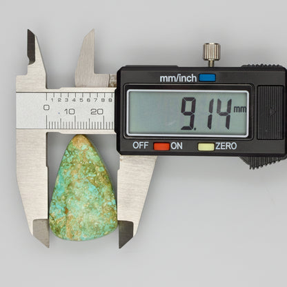 Royston Turquoise Cabochon 58.8ct measured at 9.14mm width with caliper, showcasing green-blue hues and natural matrix from Nevada.