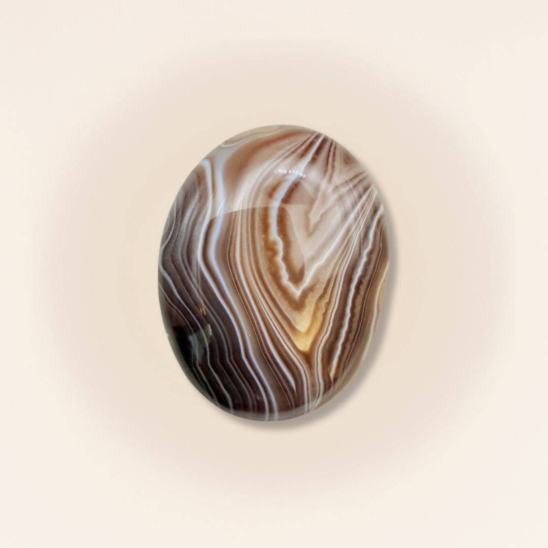 Medium Sardonyx palm stone with polished surface and intricate brown and white banding, ideal for grounding and protection rituals.